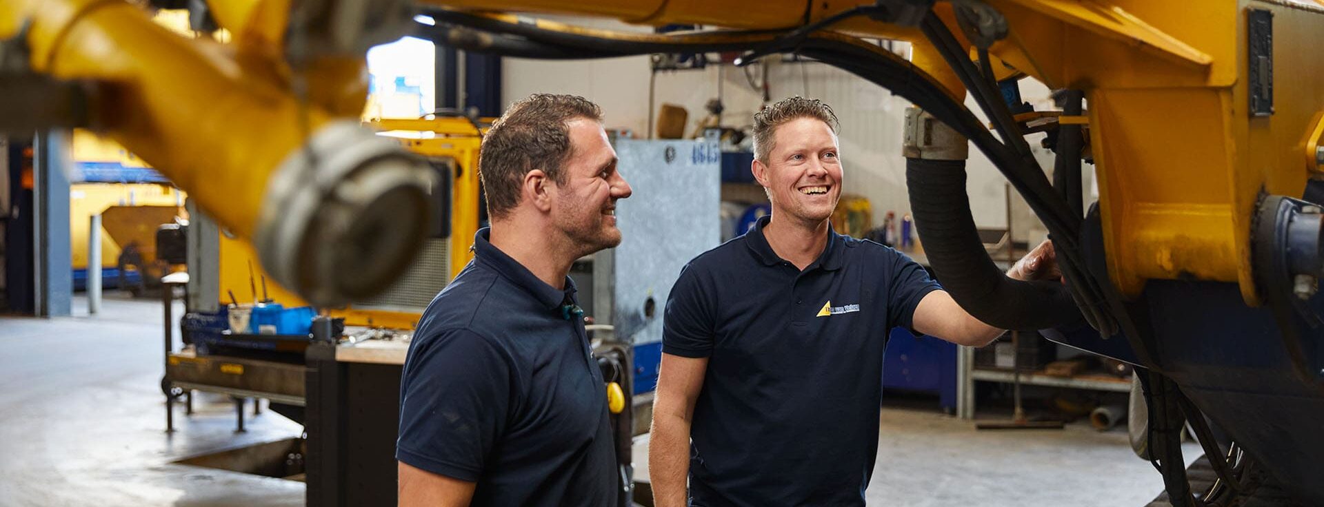 Medewerkers lachend bij machine | Theo van Velzen